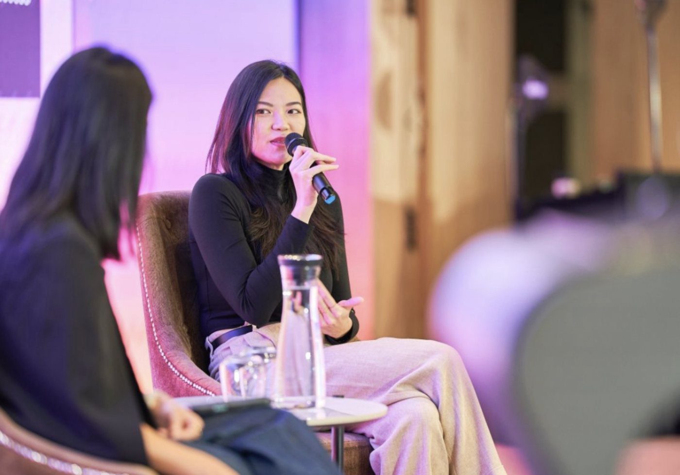 Nicole Chin speaking into a microphone during a fireside chat