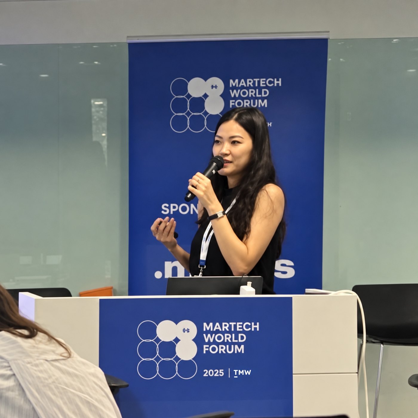 Nicole Chin speaking with a microphone at MarTech World Forum 2025 in Singapore