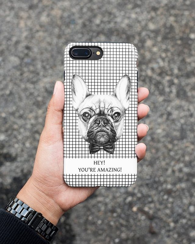 A hand holding a phone case printed with a French bulldog illustration
