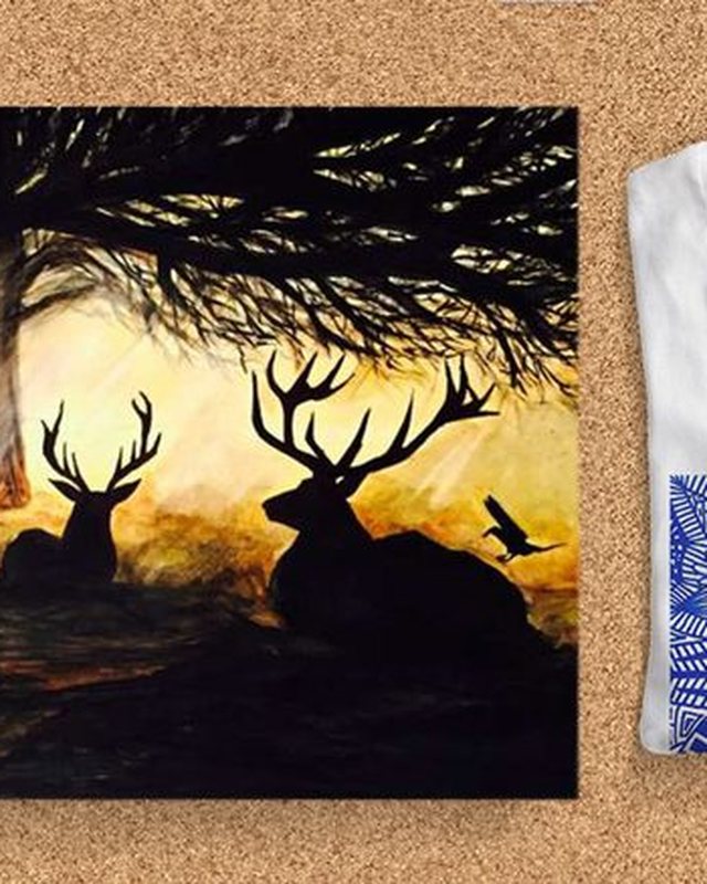 A print of stags silhouetted against a golden sunset
